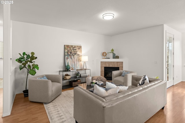 living room featuring a tile fireplace and hardwood / wood-style floors