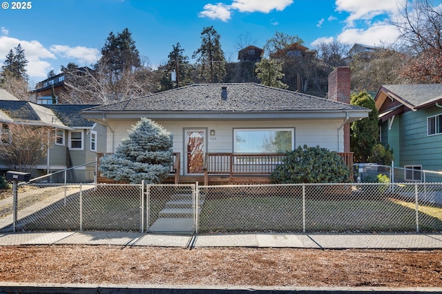 view of front of house with a fenced front yard, a gate, and a chimney