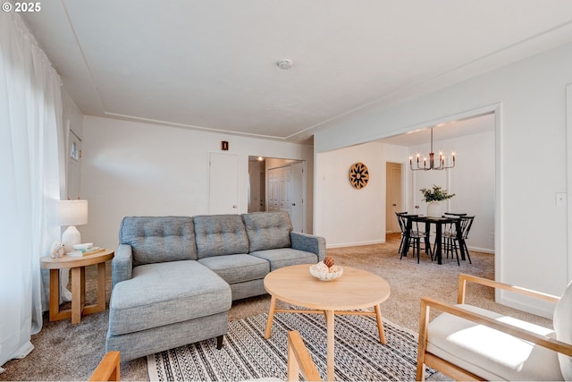 living area featuring light colored carpet, a notable chandelier, and baseboards