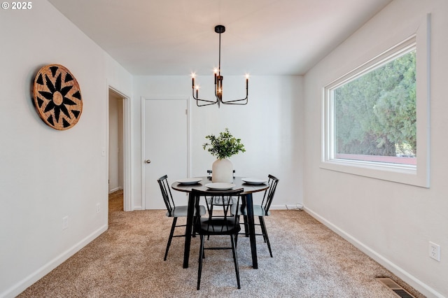 dining area with a notable chandelier, baseboards, visible vents, and light colored carpet