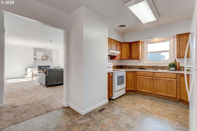 kitchen featuring white appliances, under cabinet range hood, visible vents, and light colored carpet