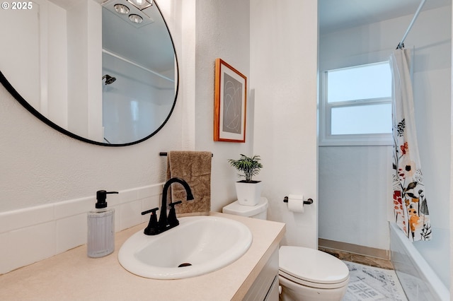 bathroom with shower / bath combination with curtain, vanity, and toilet