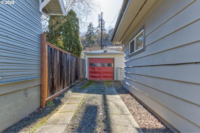 exterior space featuring driveway, a garage, and fence