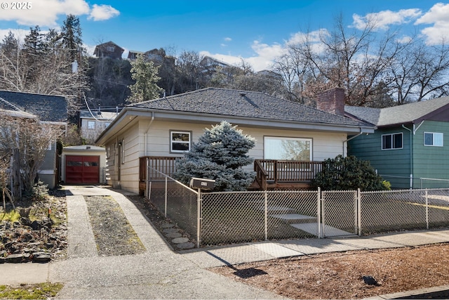 view of front of house featuring a garage, driveway, a fenced front yard, and a chimney