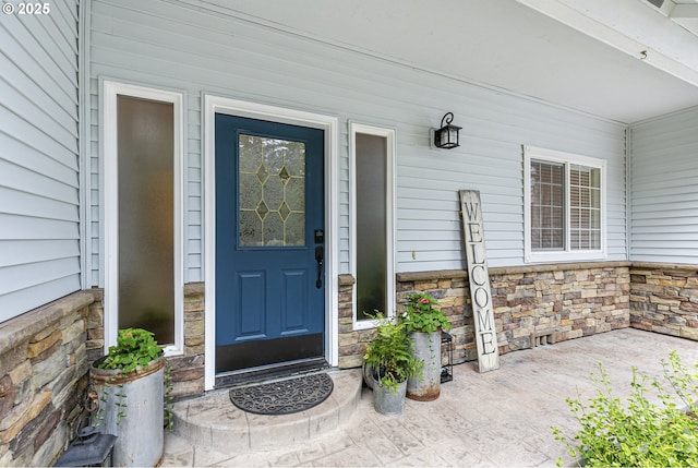 view of exterior entry featuring covered porch