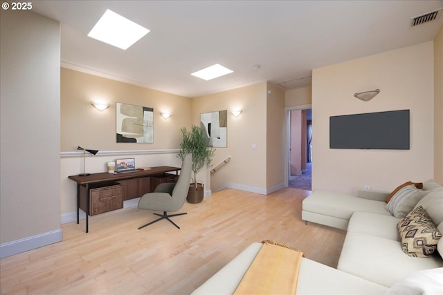 living room featuring baseboards, visible vents, and wood finished floors