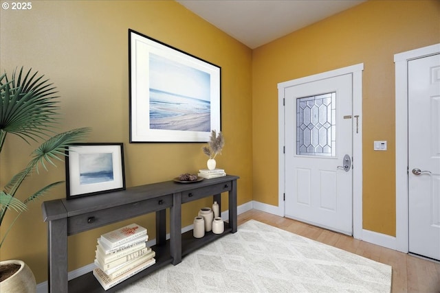 entryway featuring baseboards and wood finished floors