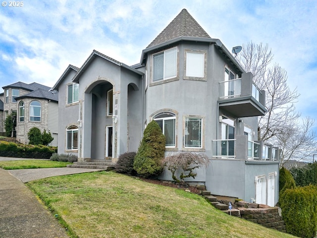 view of front facade with a front lawn, a garage, and a balcony