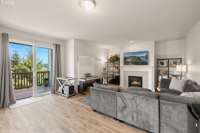 living room with a tiled fireplace and light wood-style floors