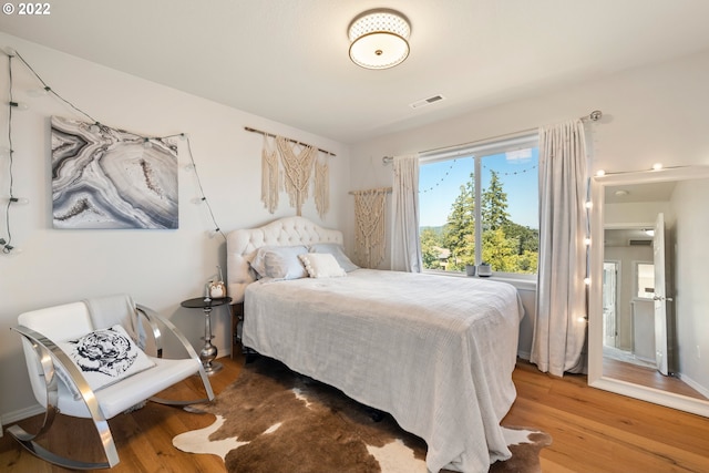 bedroom with visible vents and wood finished floors