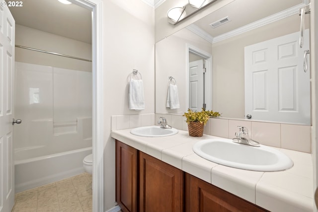 bathroom featuring a sink, crown molding, double vanity, and visible vents