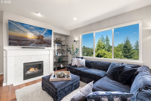 living area featuring recessed lighting, a wealth of natural light, wood finished floors, and a fireplace