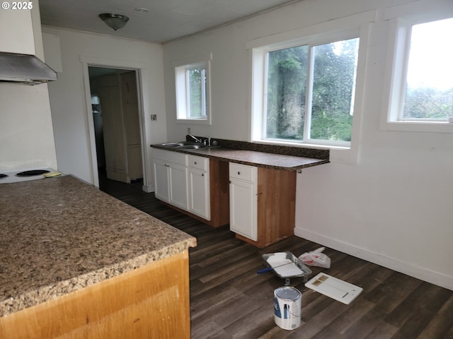 kitchen featuring white cabinets, wall chimney exhaust hood, stovetop, sink, and dark hardwood / wood-style floors