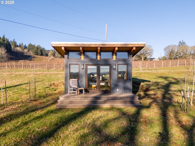 view of outbuilding with a lawn, a rural view, and french doors