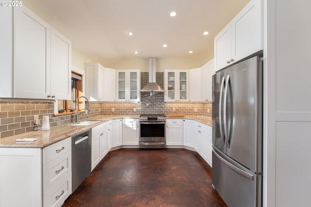 kitchen with wall chimney range hood, stainless steel appliances, white cabinets, and sink