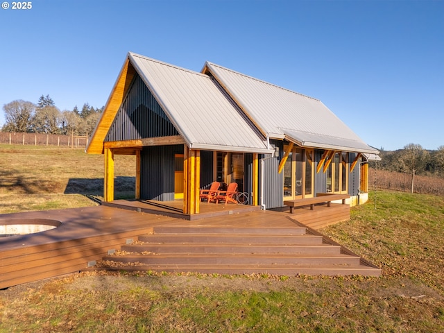 back of house with a wooden deck and a yard