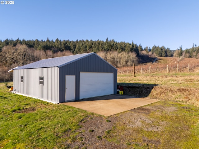 garage featuring a yard and a rural view