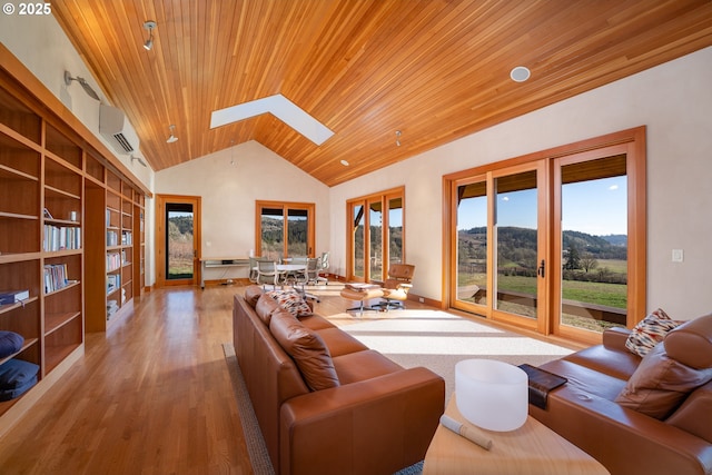 living room with built in features, wooden ceiling, a mountain view, a wall mounted air conditioner, and light hardwood / wood-style floors