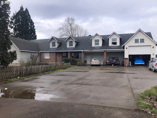 view of front of property featuring brick siding and fence