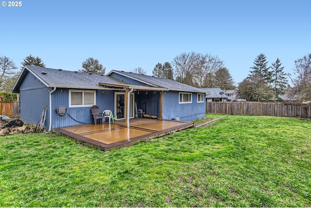 rear view of property featuring a yard, a deck, and a fenced backyard