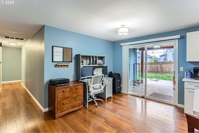 office with visible vents, light wood-type flooring, and baseboards