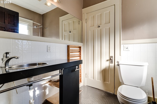 bathroom featuring tile walls, sink, and toilet