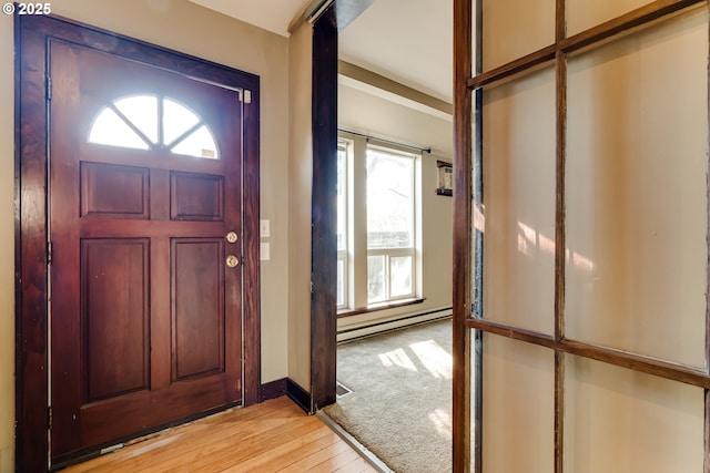 entrance foyer featuring a baseboard radiator and light hardwood / wood-style floors