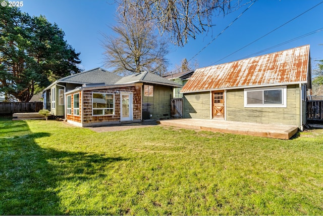 back of property with a wooden deck and a yard