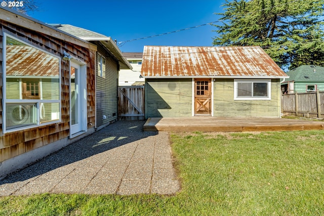 rear view of property with a wooden deck and a lawn