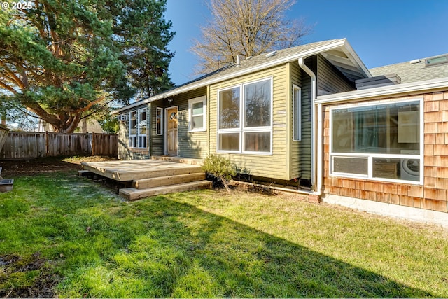 rear view of house with a deck and a lawn