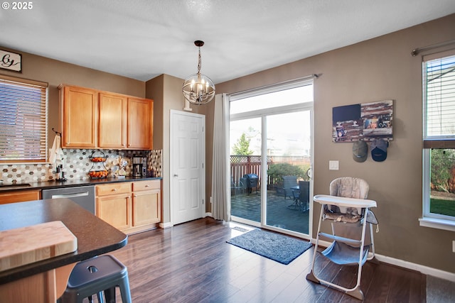 kitchen with dark wood-style flooring, dark countertops, backsplash, stainless steel dishwasher, and baseboards