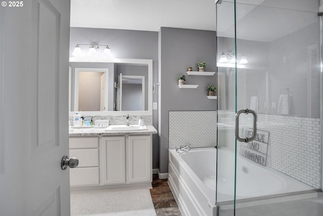 bathroom featuring a bathtub, wood finished floors, vanity, and an enclosed shower