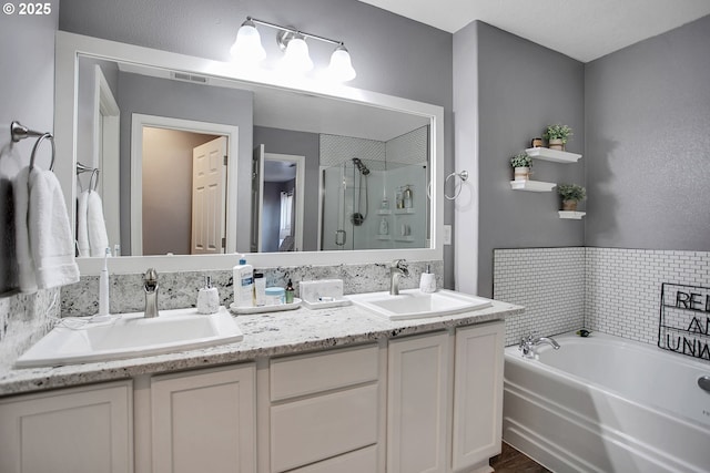 full bathroom featuring double vanity, a garden tub, a shower stall, and a sink