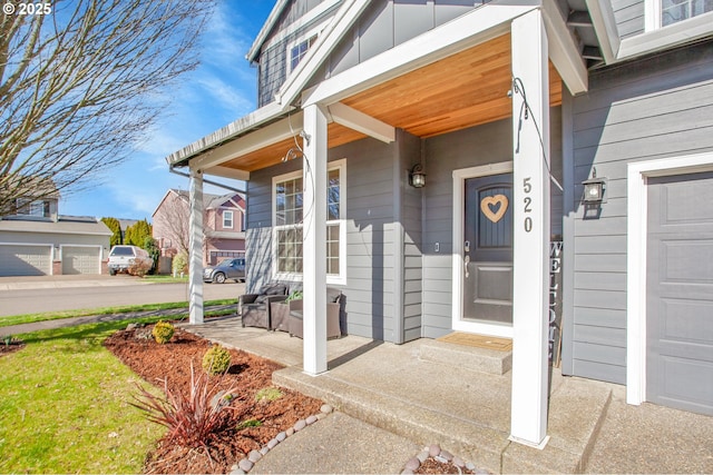 view of exterior entry with covered porch and a garage