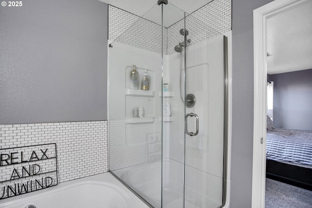 bathroom featuring a shower stall, ensuite bath, and a bath