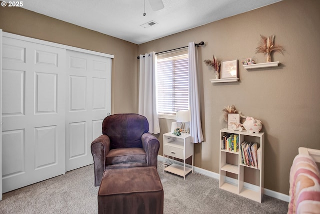 living area featuring a ceiling fan, baseboards, visible vents, and carpet flooring