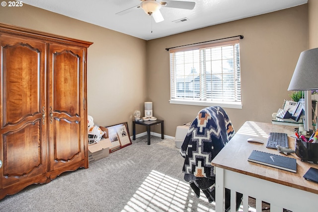 office featuring carpet floors, baseboards, visible vents, and a ceiling fan