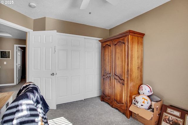 bedroom featuring light carpet, ceiling fan, baseboards, and a closet