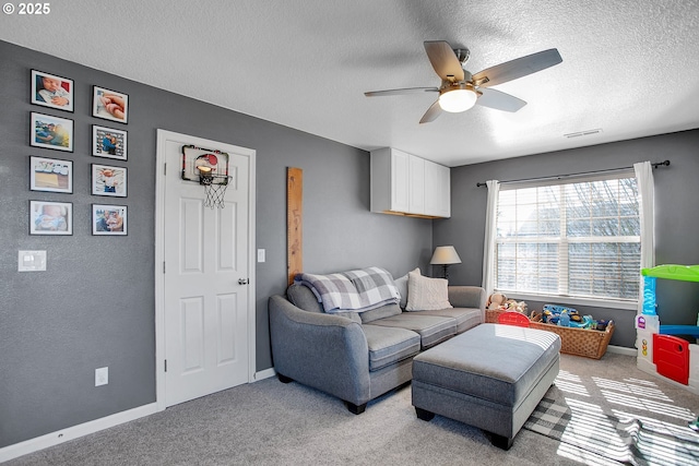 living area with baseboards, visible vents, a ceiling fan, light colored carpet, and a textured ceiling