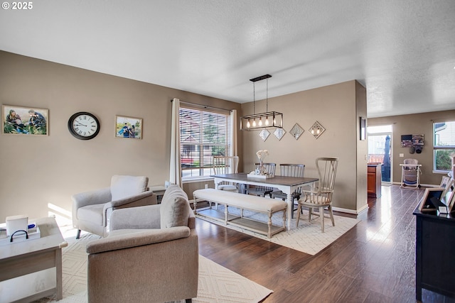 dining room featuring a textured ceiling, baseboards, and dark wood-style flooring