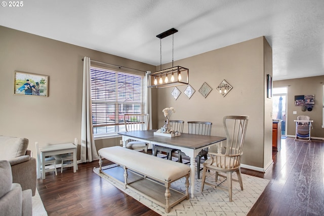 dining area with a textured ceiling, dark wood finished floors, and baseboards