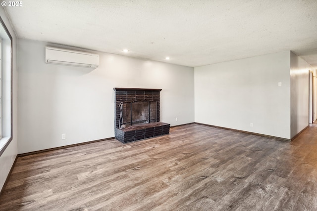 1885 N Danebo Ave, Eugene, OR 97402 - unfurnished living room featuring a wall mounted air conditioner, wood finished floors, recessed lighting, baseboards, and a fireplace