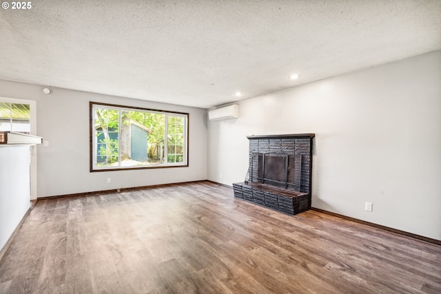 1885 N Danebo Ave, Eugene, OR 97402 - unfurnished living room featuring an AC wall unit, wood finished floors, a brick fireplace, baseboards, and recessed lighting