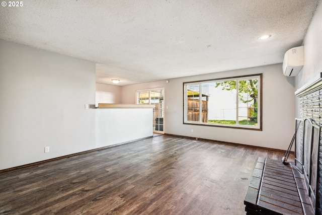 1885 N Danebo Ave, Eugene, OR 97402 - unfurnished living room featuring a wall mounted air conditioner, a textured ceiling, a fireplace, wood finished floors, and baseboards