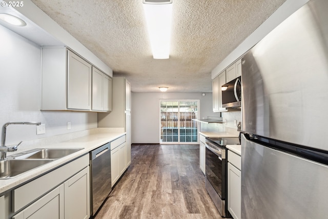 1885 N Danebo Ave, Eugene, OR 97402 - kitchen featuring stainless steel appliances, a sink, a textured ceiling, light wood finished floors, and light countertops