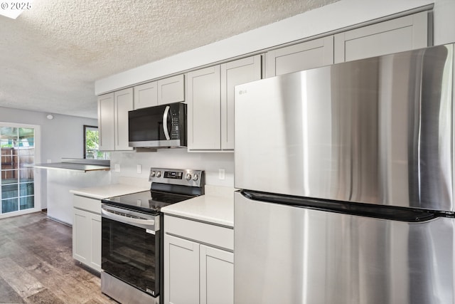 1885 N Danebo Ave, Eugene, OR 97402 - kitchen featuring appliances with stainless steel finishes, a textured ceiling, light wood-style floors, light countertops, and gray cabinetry
