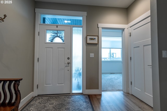 foyer with baseboards and light wood-style floors