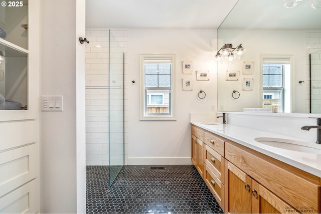 bathroom with walk in shower, a sink, and tile patterned flooring