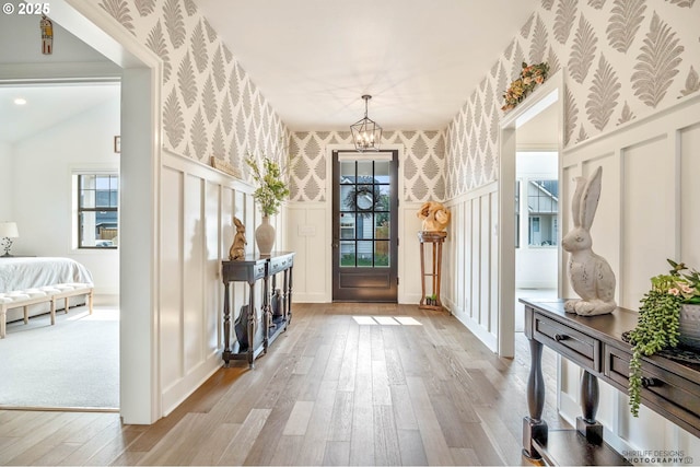 interior space featuring a decorative wall, a healthy amount of sunlight, hardwood / wood-style flooring, and wallpapered walls