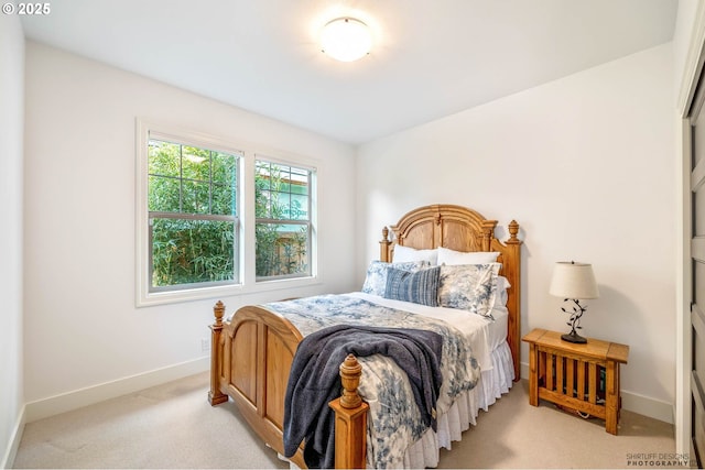 bedroom with baseboards and light carpet